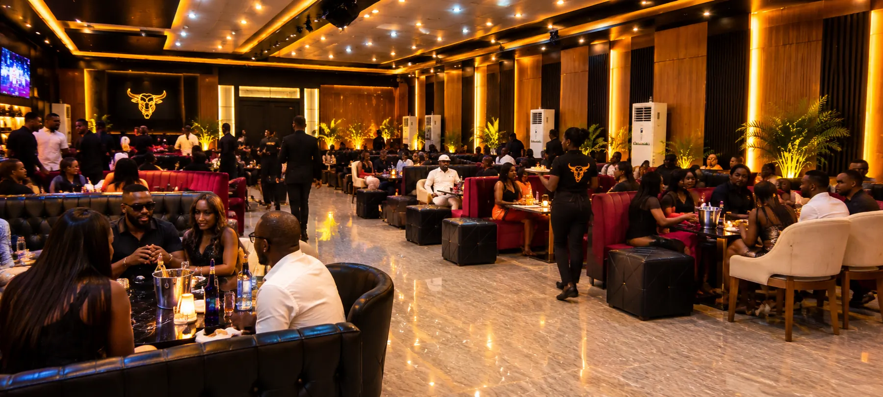 Full dining room of guests seated across booths and tables under warm lighting